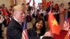 Tổng thống Mỹ Donald Trump cầm cờ Việt Nam khi được học sinh chào đón tại Văn phòng Chính phủ ở Hà Nội, Việt Nam, ngày 27/2/2019.